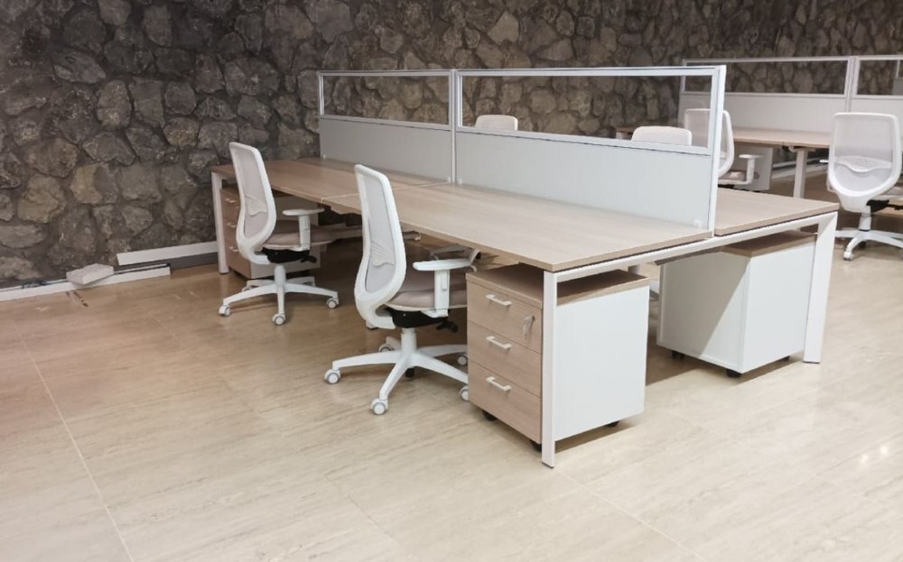 Puestos de trabajo con sillas ergonómicas y escritorios modulares en oficina moderna.