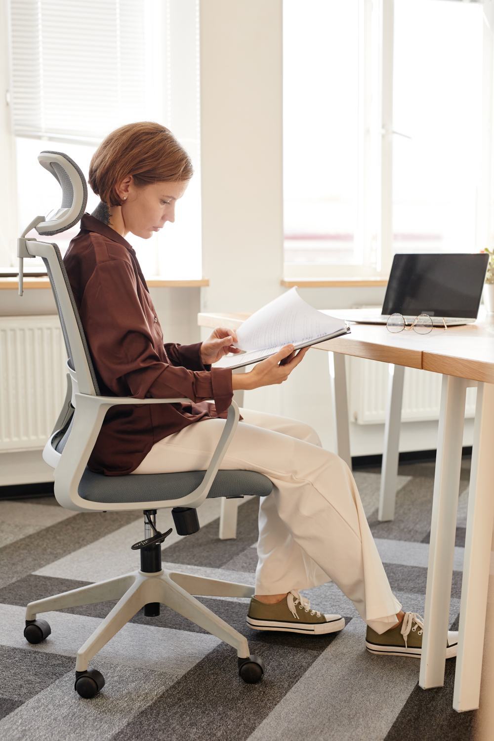 Mujer en silla ergonómica sostiene documento de Coremosa junto a técnico