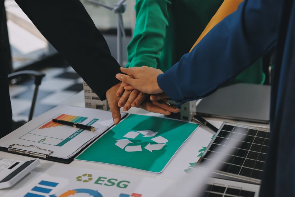 Manos de profesionales sobre símbolo de reciclaje y gráficos ESG para reducir impacto ambiental consumibles.
